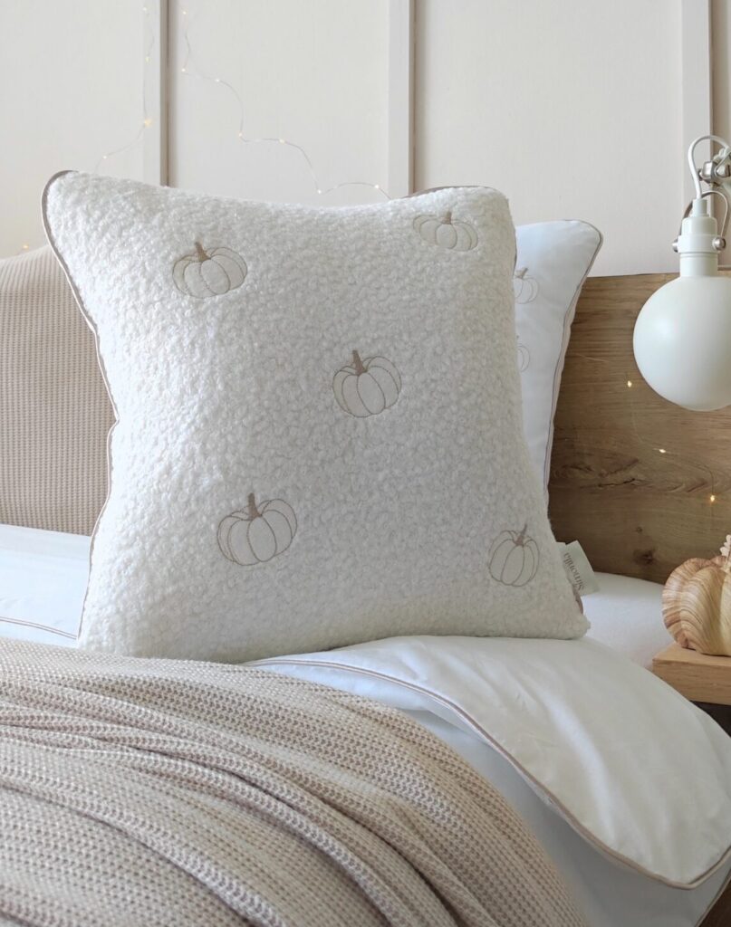 Jesienna poduszka z pięcioma haftowanymi dyniami w odcieniach biało-beżowych bestseller kolekcji Simonila, elegancka dekoracyjna salonu i sypialni