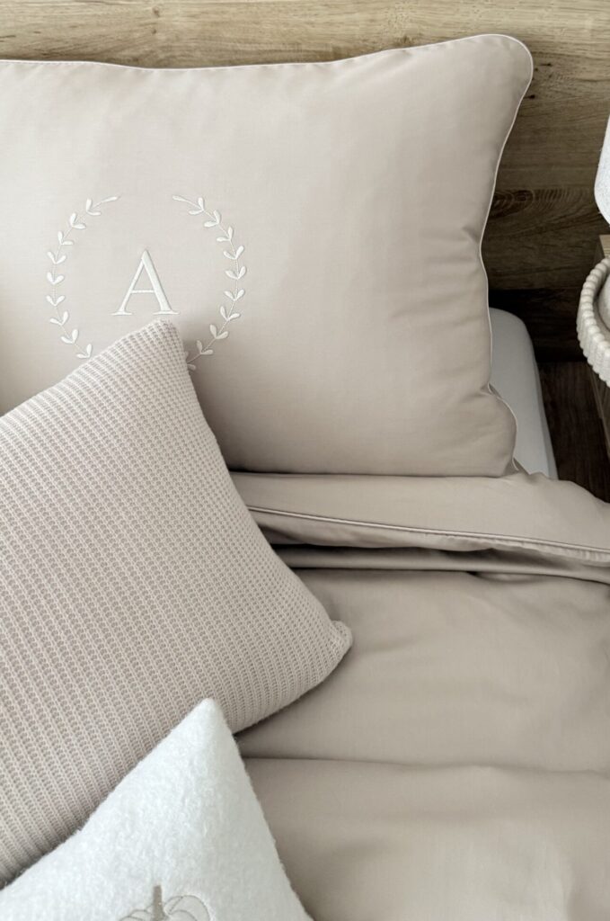 Zbliżenie haftu inicjału A z atłasową wypustką - komplet pościeli chłodny beż Simonila.