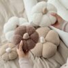 Ręcznie robiona poduszka dynia z miękkiego materiału boucle, z wypełnieniem, trzymana w dłoniach - produkt Simonila z jesiennej kolekcji
