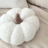 Ręcznie robiona poduszka dynia z miękkiego materiału boucle, z wypełnieniem, trzymana w dłoniach - produkt Simonila z jesiennej kolekcji