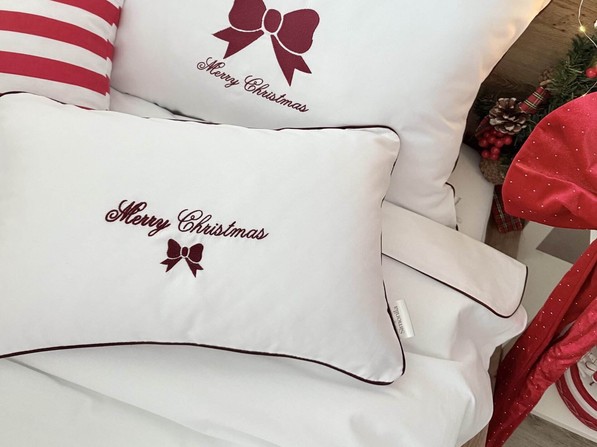 Świąteczna poduszka z bordowym haftem Merry Christmas i bordową wypustką