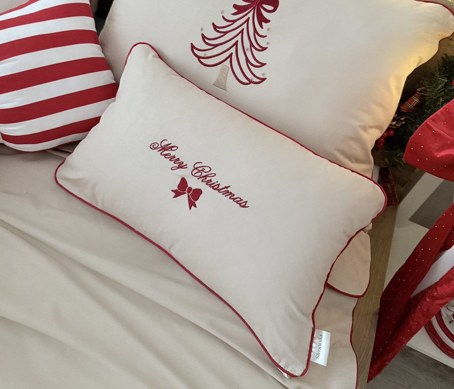 Świąteczna poduszka beżowa z haftem Merry Christmas i czerwoną wypustką