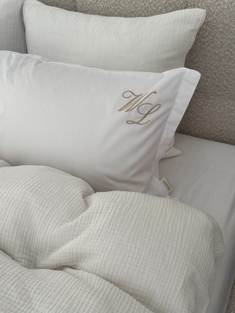 pościel satynowa pure biała z monogramem na łóżku